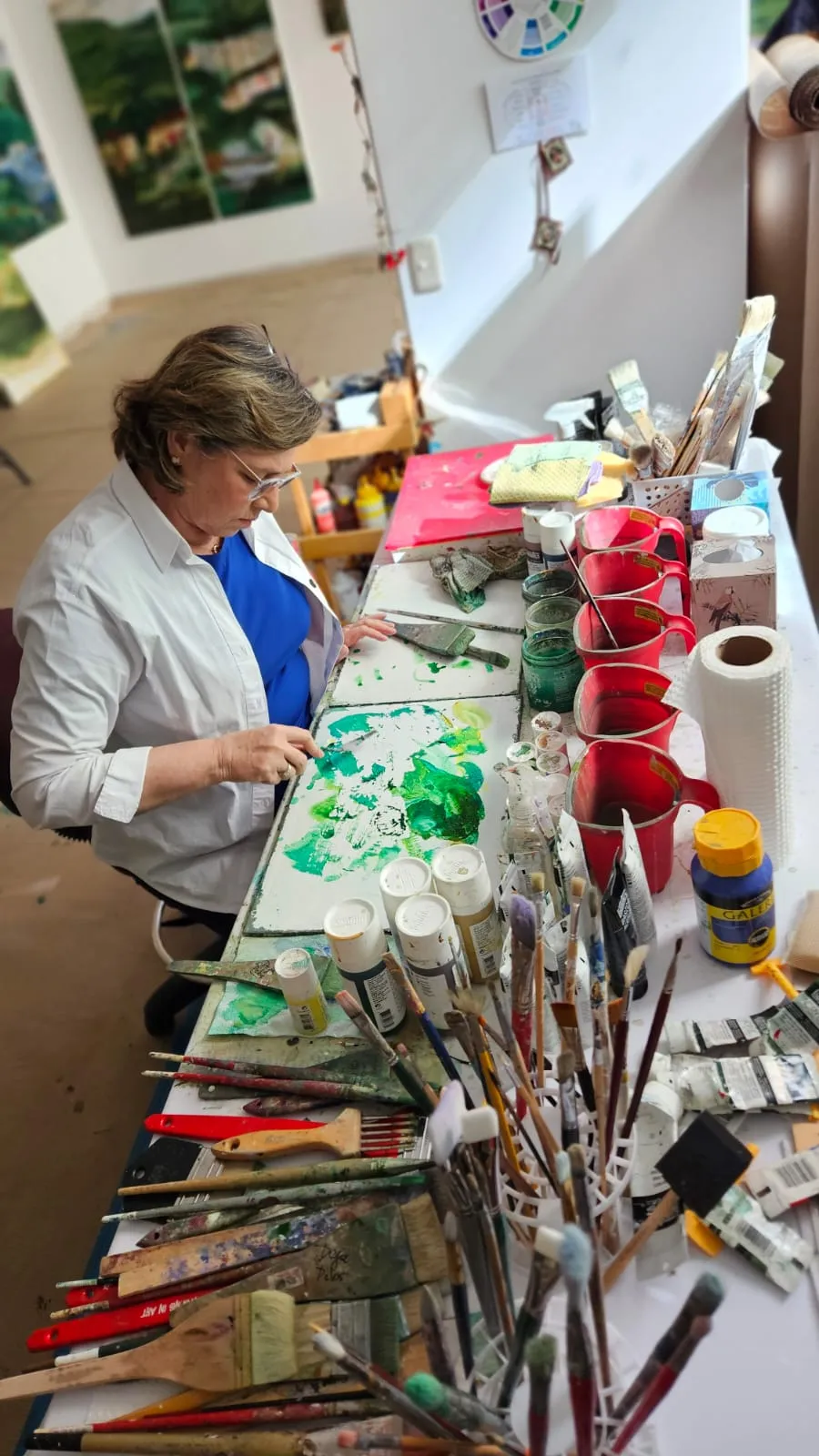 Artist in studio with paintings